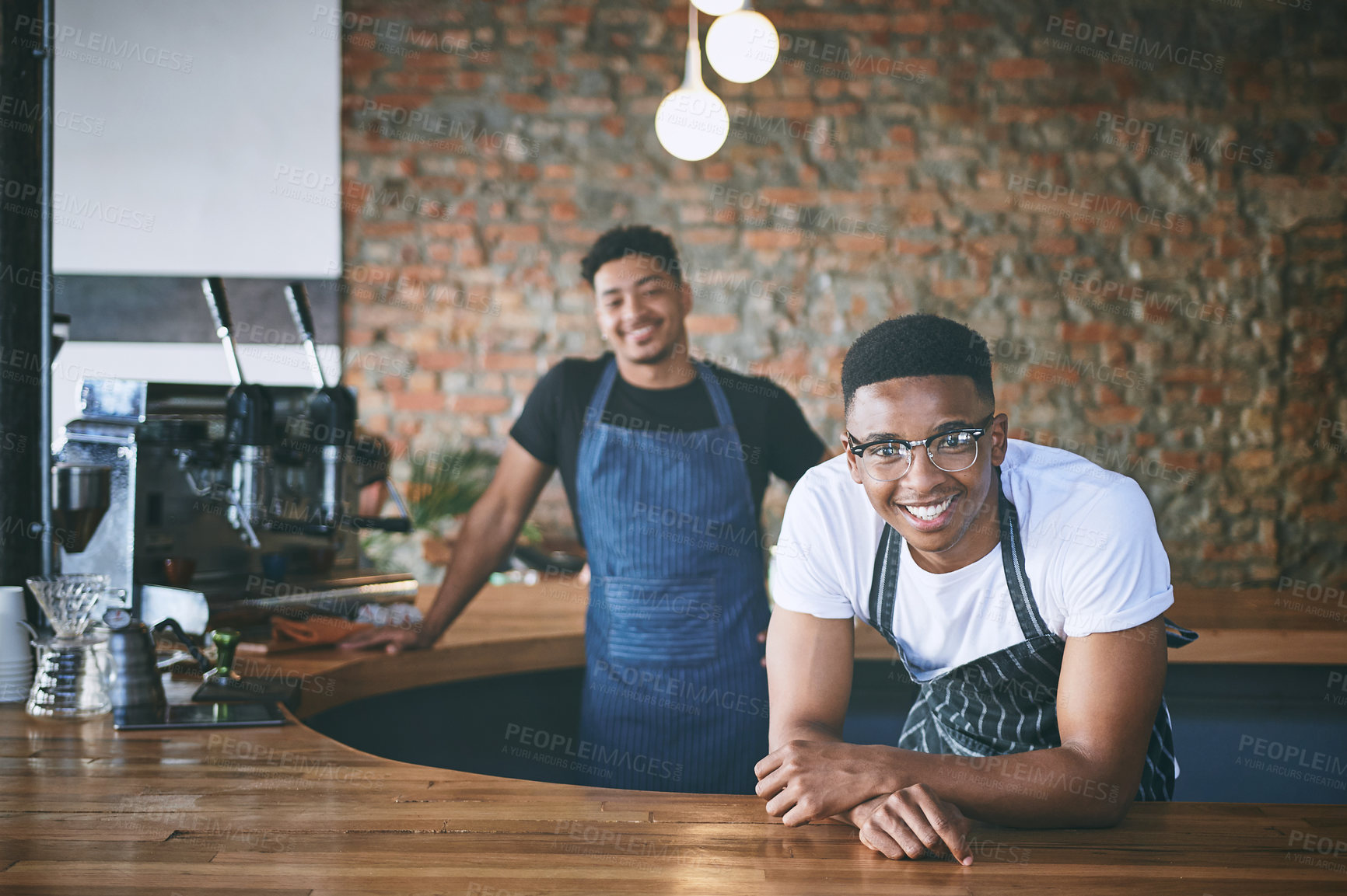 Buy stock photo Shot of two confident young men working in a cafe