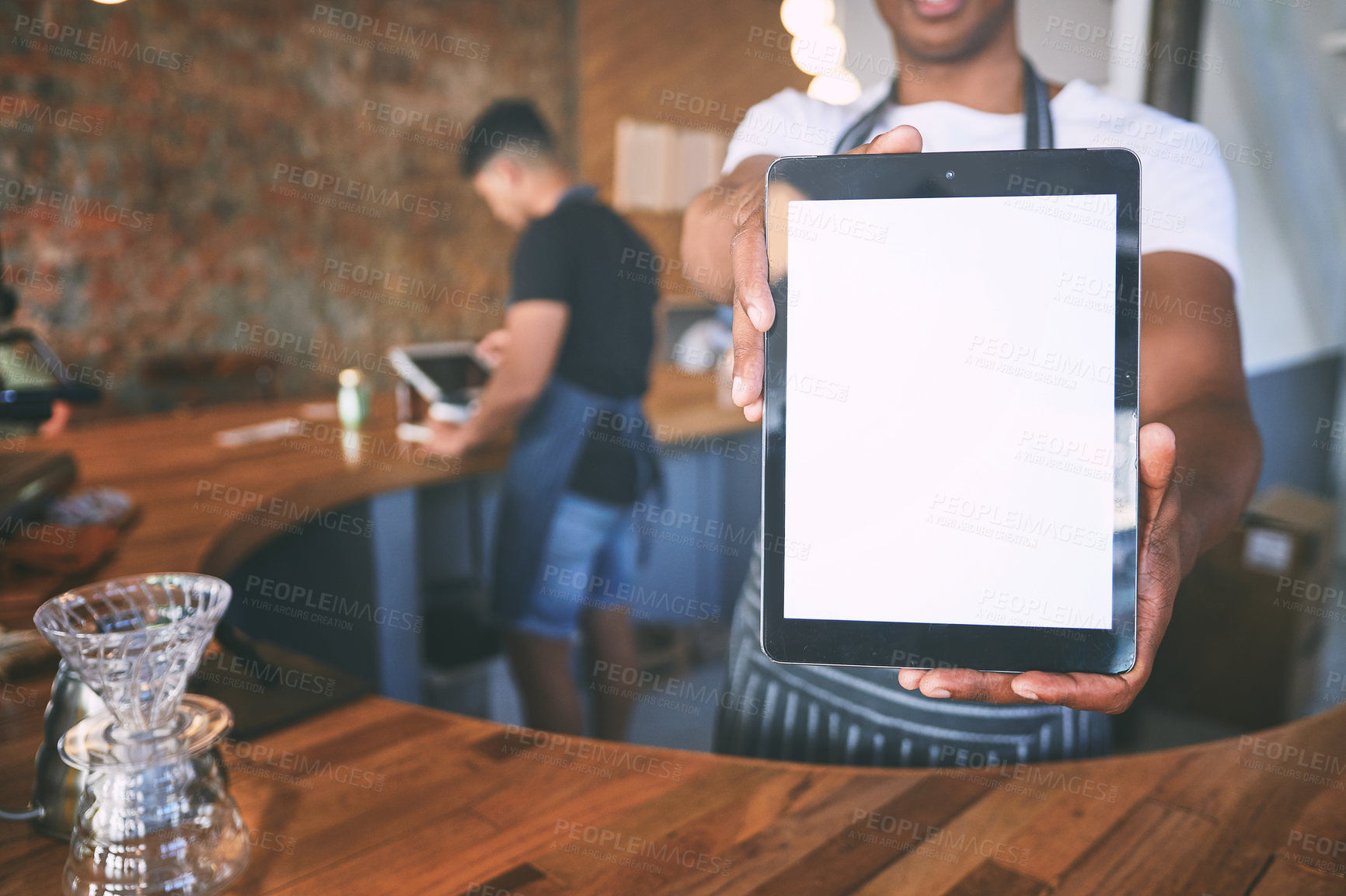 Buy stock photo Shot of a man showing a digital tablet with a blank screen while working in a cafe
