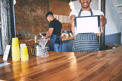 Buy stock photo Shot of a man showing a digital tablet with a blank screen while working in a cafe