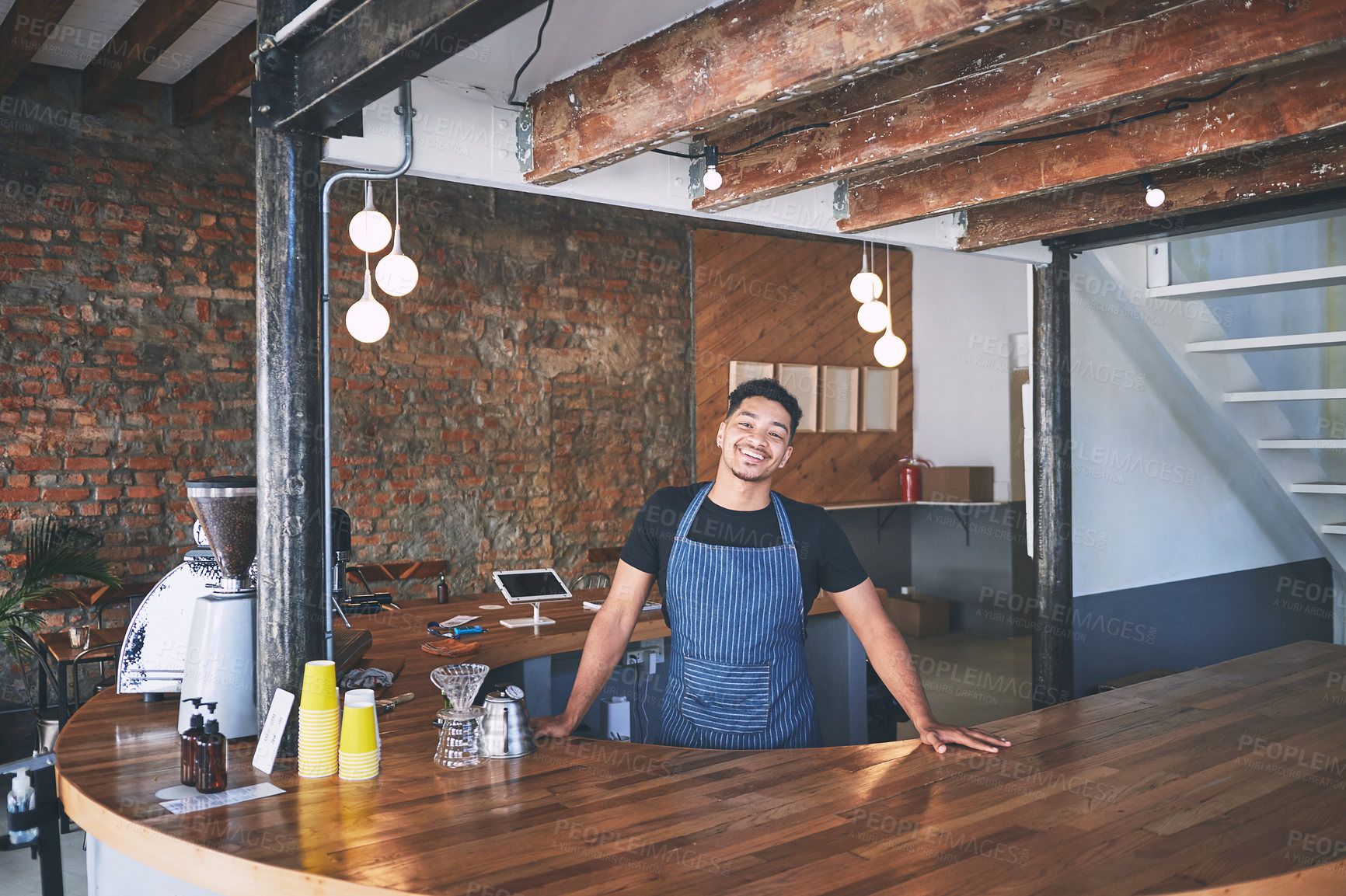 Buy stock photo Shot of a confident young man working in a cafe