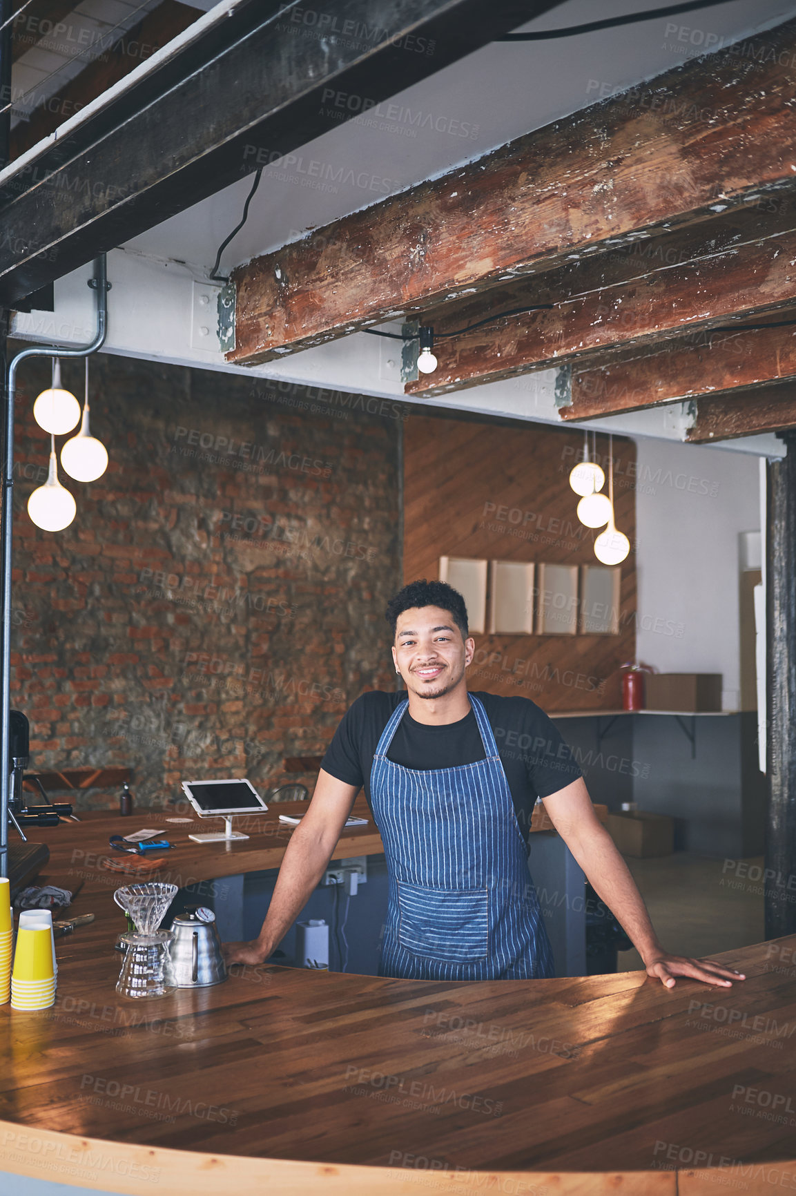 Buy stock photo Shot of a confident young man working in a cafe