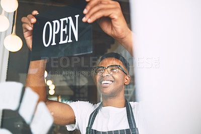 Buy stock photo Shot of a young man hanging up an open sign while working in a cafe