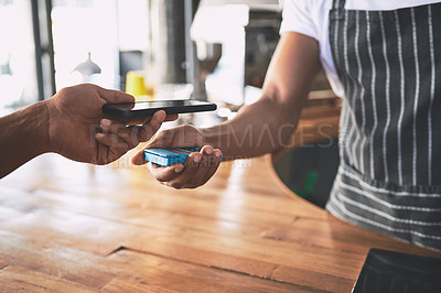 Buy stock photo Shot of an unrecognisable man using a smartphone to make a payment in a cafe
