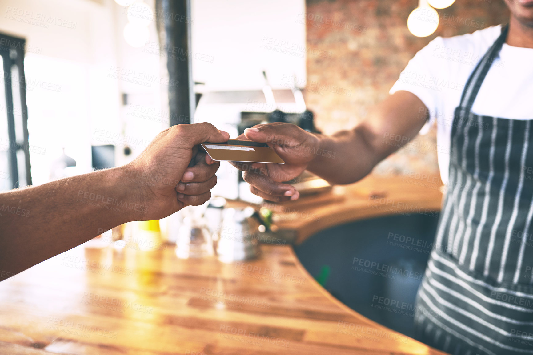 Buy stock photo Shot of a man using a credit card to make a payment in a cafe