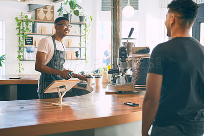 Buy stock photo Shot of a young man being served coffee in a cafe
