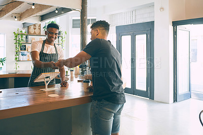Buy stock photo Shot of a young man buying coffee in a cafe