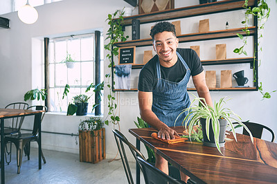 Buy stock photo Shot of a young wiping a table while working in a cafe