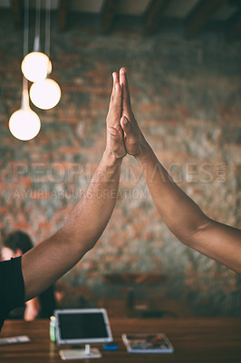 Buy stock photo Shot of two unrecognisable men giving each other a high five while working in a cafe