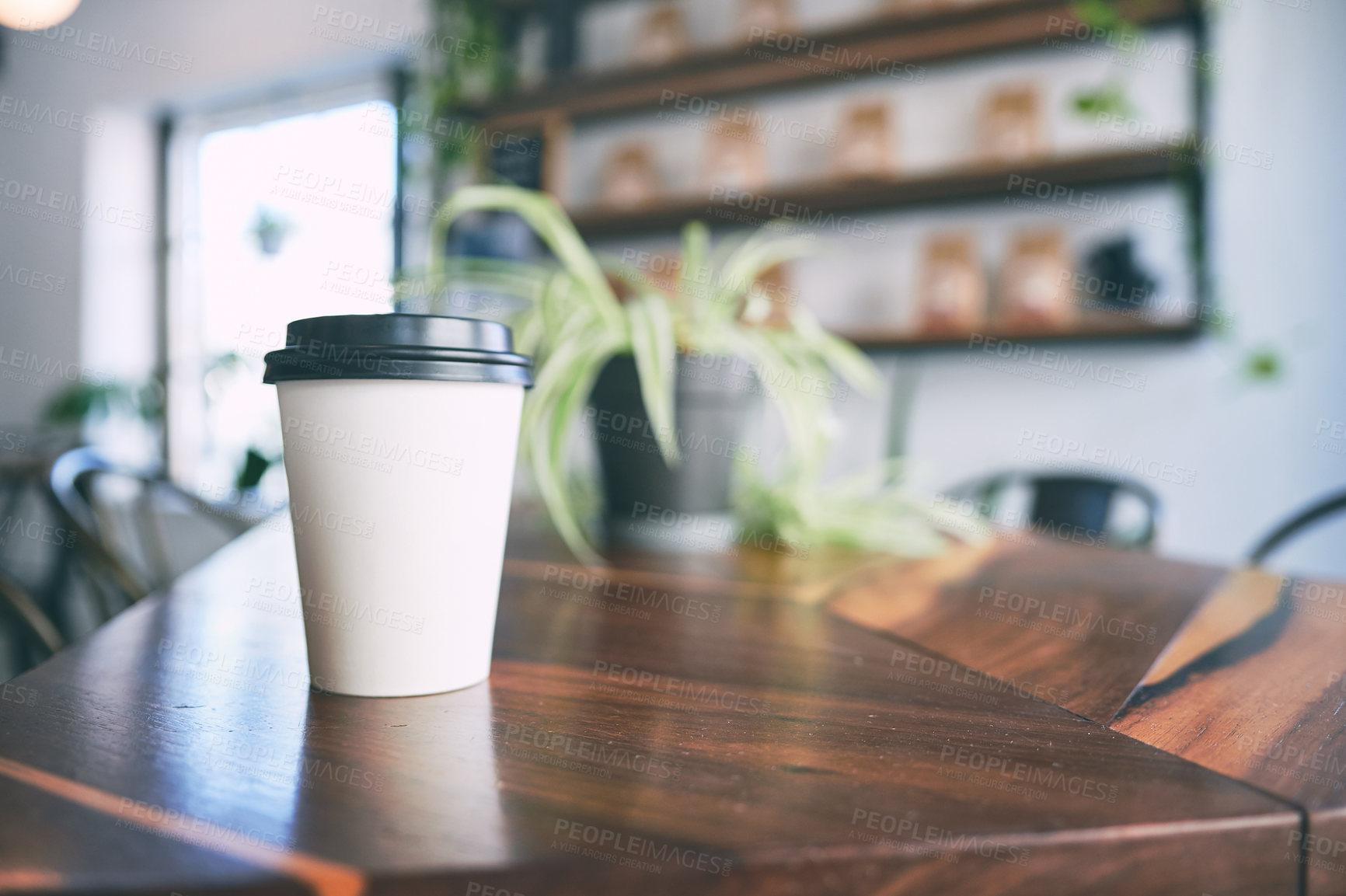 Buy stock photo Shot of a paper cup on a counter in an empty cafe
