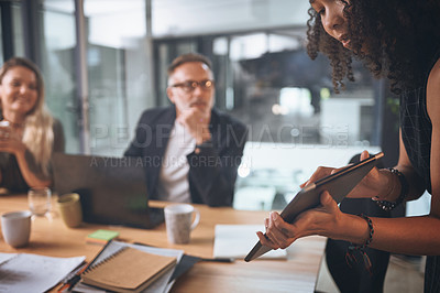 Buy stock photo Shot of a young businesswoman using a digital tablet while delivering a presentation in the boardroom of a modern office