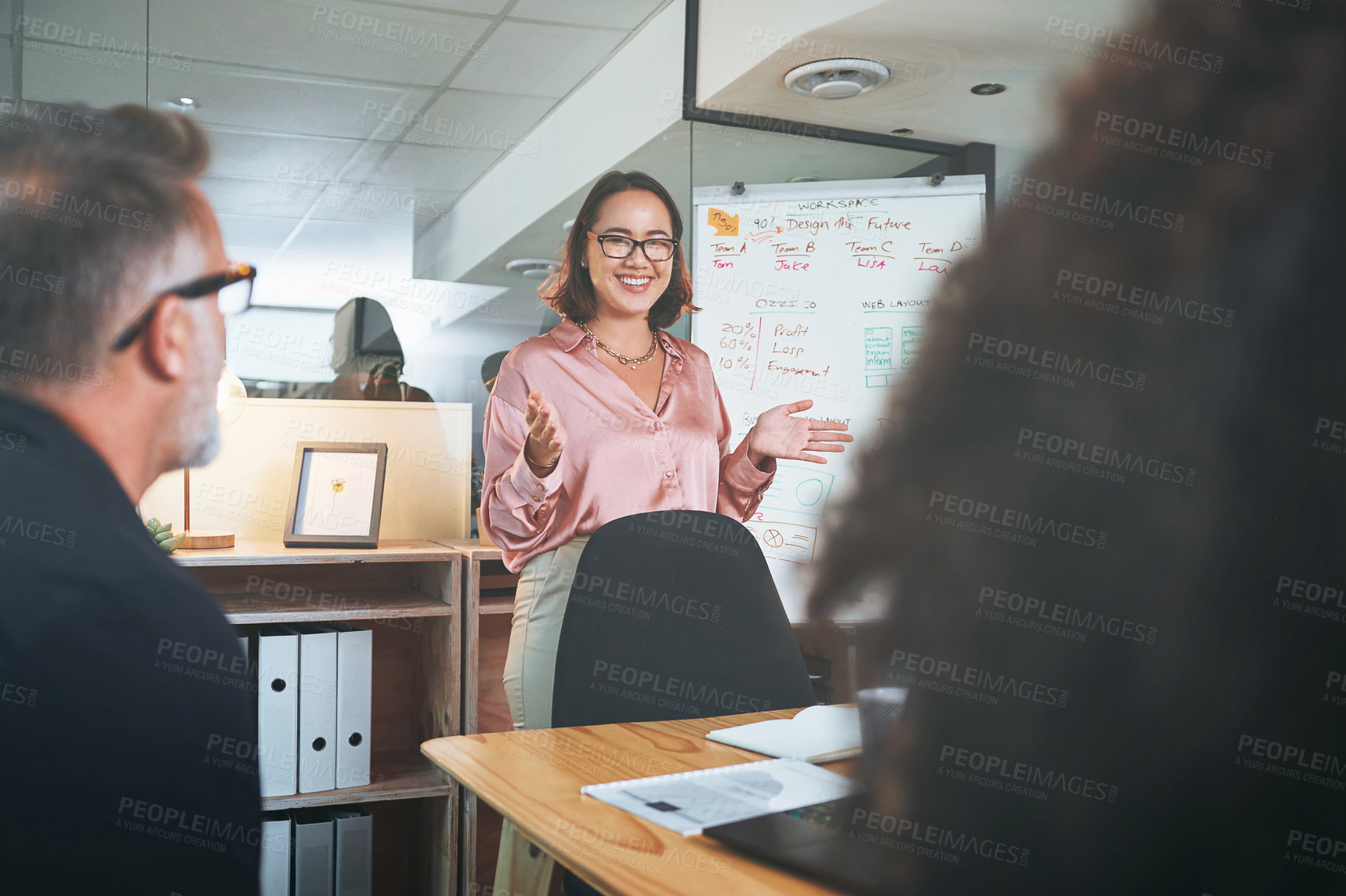 Buy stock photo Shot of a young businesswoman delivering a presentation to her coworkers in the boardroom of a modern office