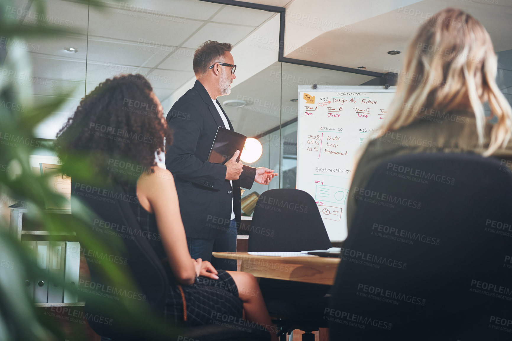 Buy stock photo Shot of a mature businessman delivering a presentation in the boardroom of a modern office