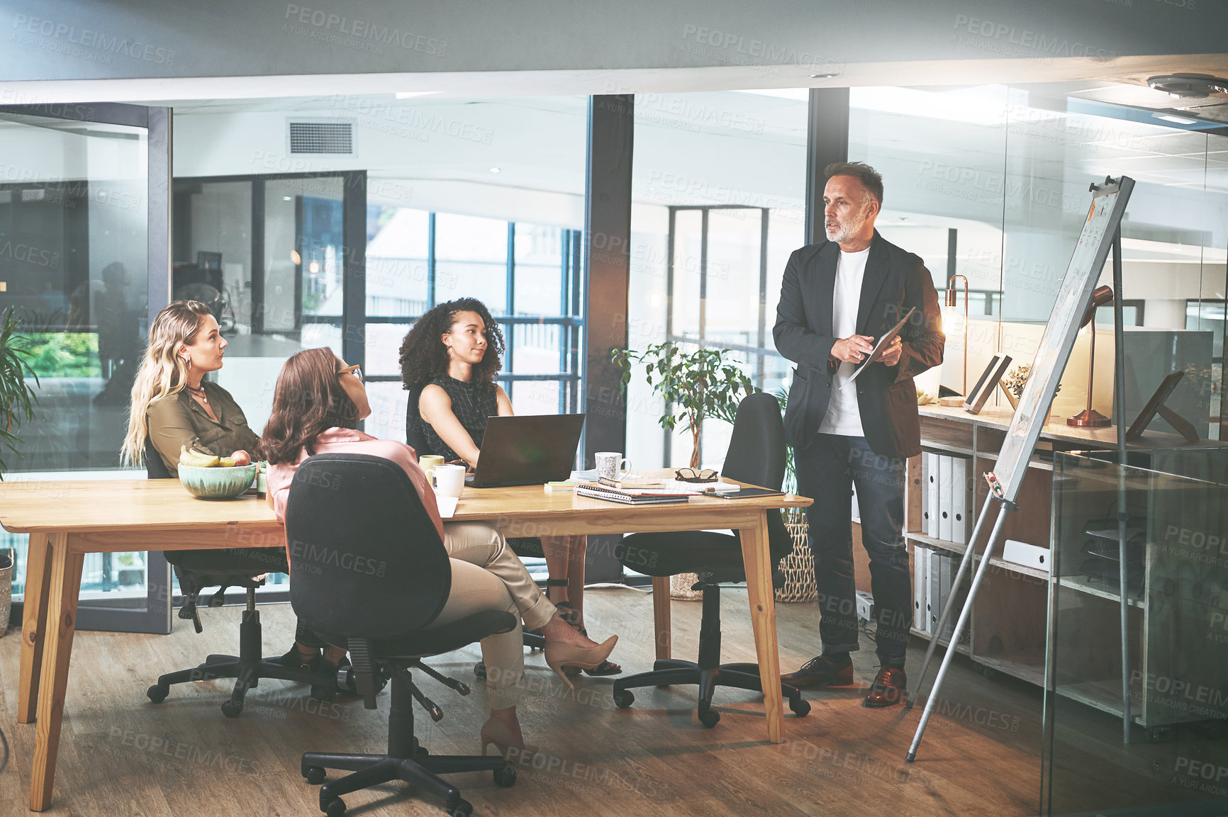 Buy stock photo Shot of a mature businessman delivering a presentation in the boardroom of a modern office