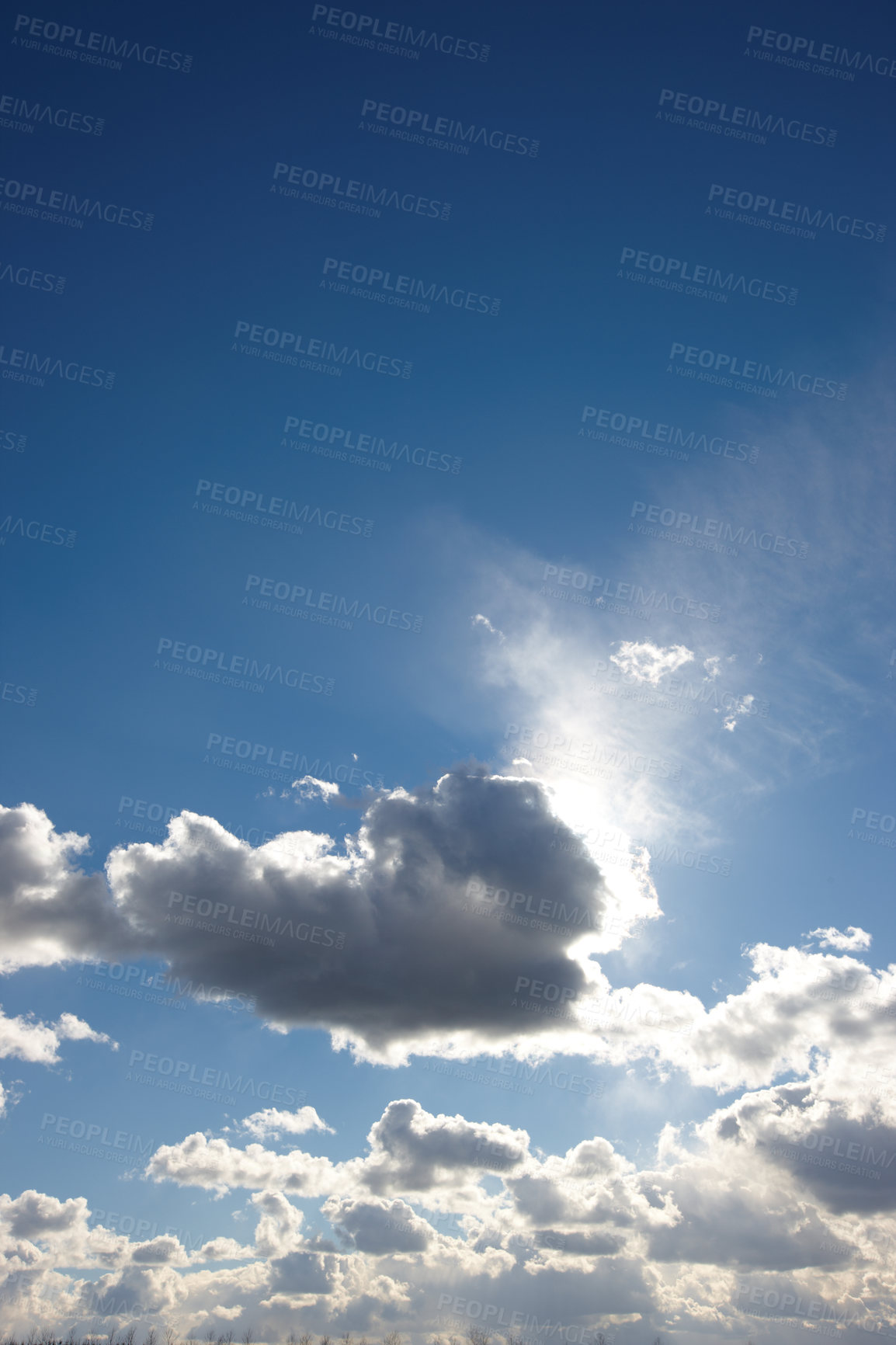 Buy stock photo Copyspace scenic view of a blue cloudy sky with sun shining through. Low landscape view of a cumulus cloud blocking the sun on a sunny day. Beautiful scenery of heavenly clouds with sunlight