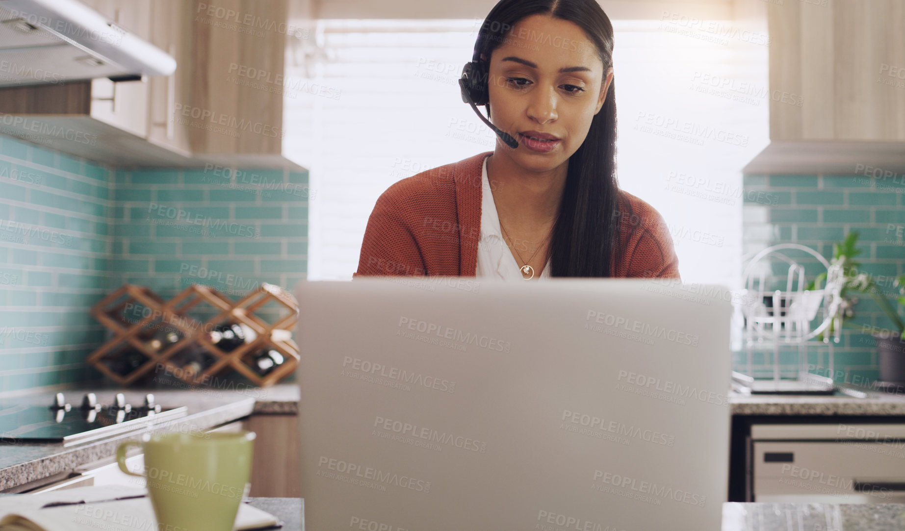 Buy stock photo Shot of a young female teleworker working as a call center agent at home