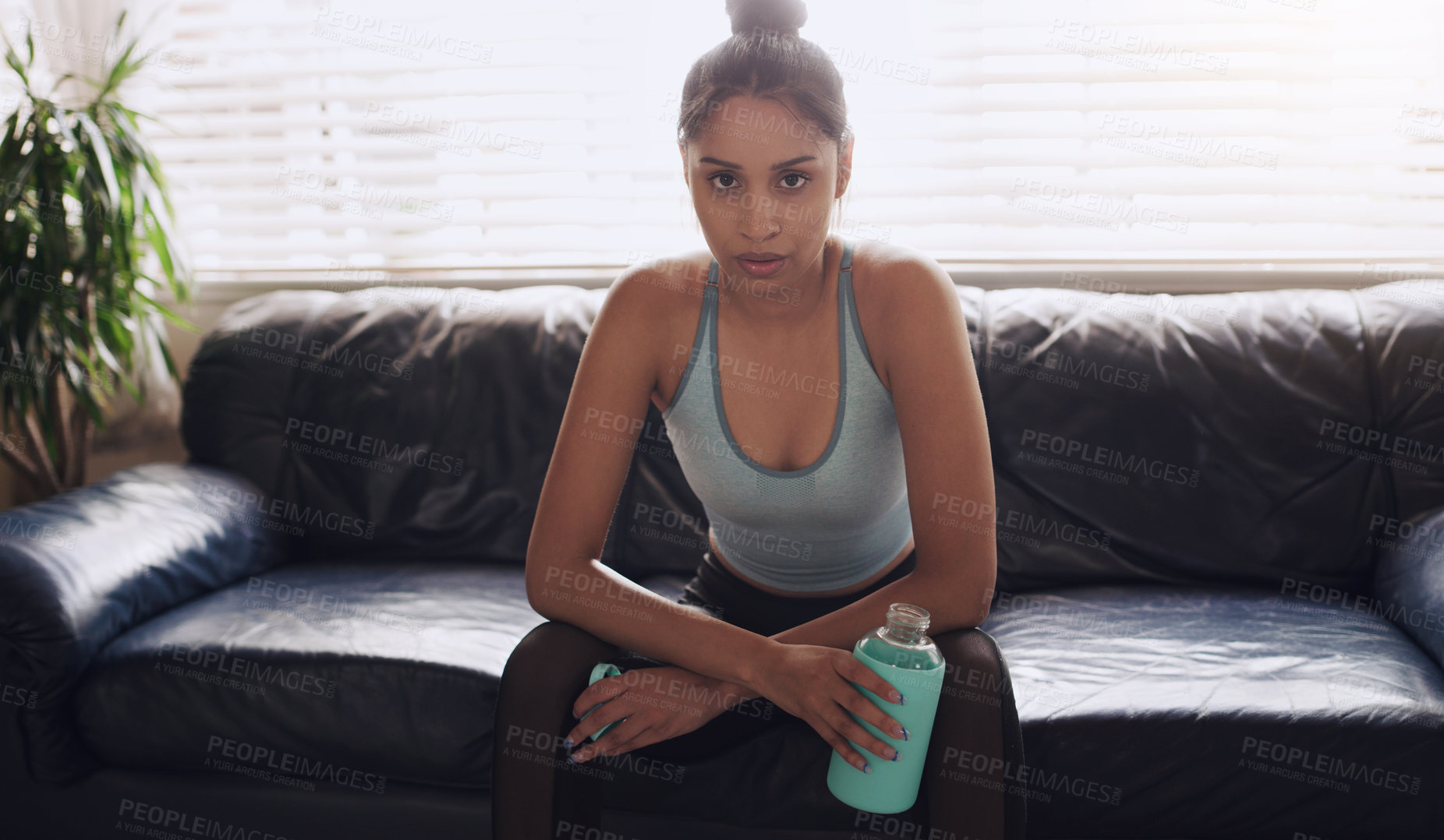 Buy stock photo Shot of a young woman cooling down completing her workout routine at home