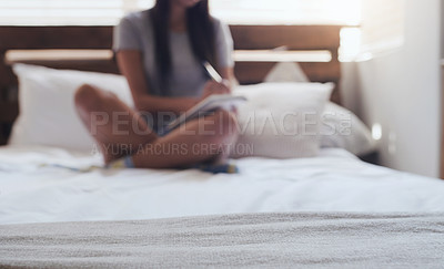 Buy stock photo Shot of a young woman sitting in bed while writing in her diary at home