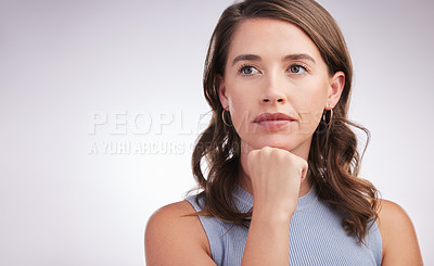Buy stock photo Studio shot of a young woman looking thoughtful against a grey background