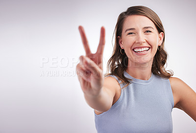 Buy stock photo Portrait, woman and peace sign with smile, feedback and agreement on grey studio background. Face, person or girl with hand gesture, review or emoji with support, wellness or carefree with good vibes