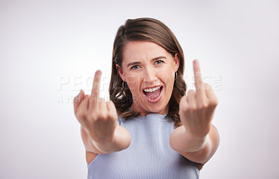 Buy stock photo Studio portrait of a young woman showing middle finger against a grey background