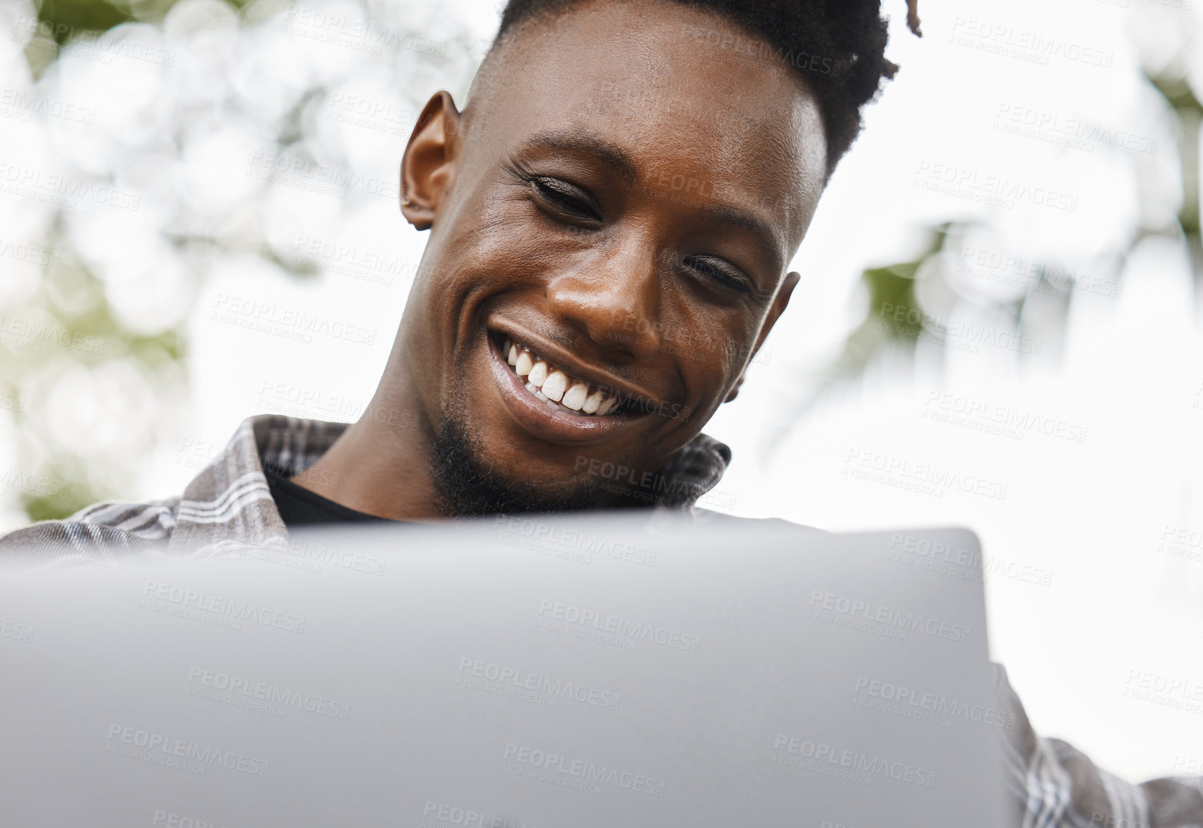 Buy stock photo Shot of a young man using a laptop on campus