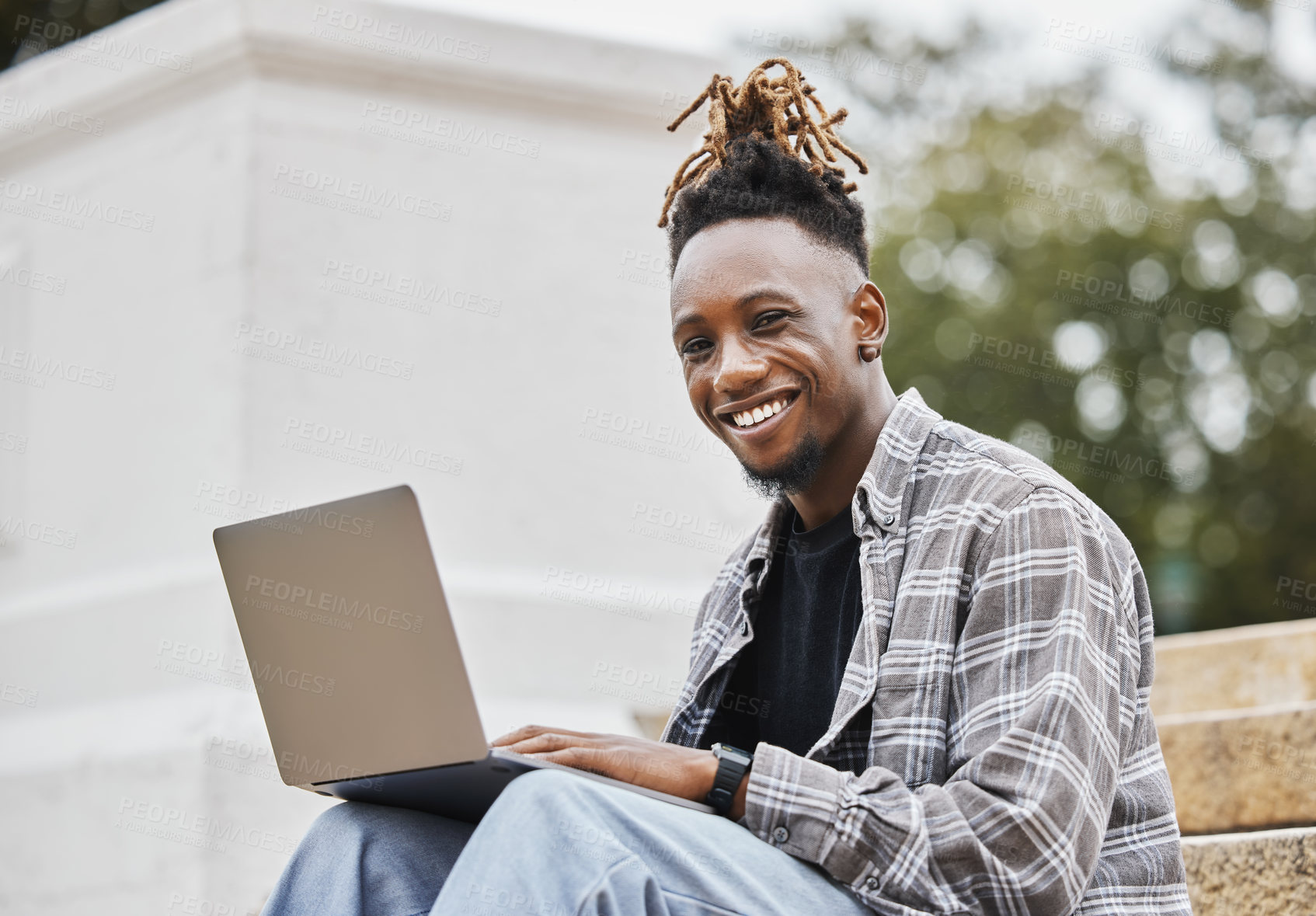Buy stock photo Shot of a young man using a laptop on campus