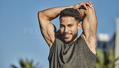 Buy stock photo Portrait of a sporty young man stretching his arms while exercising outdoors