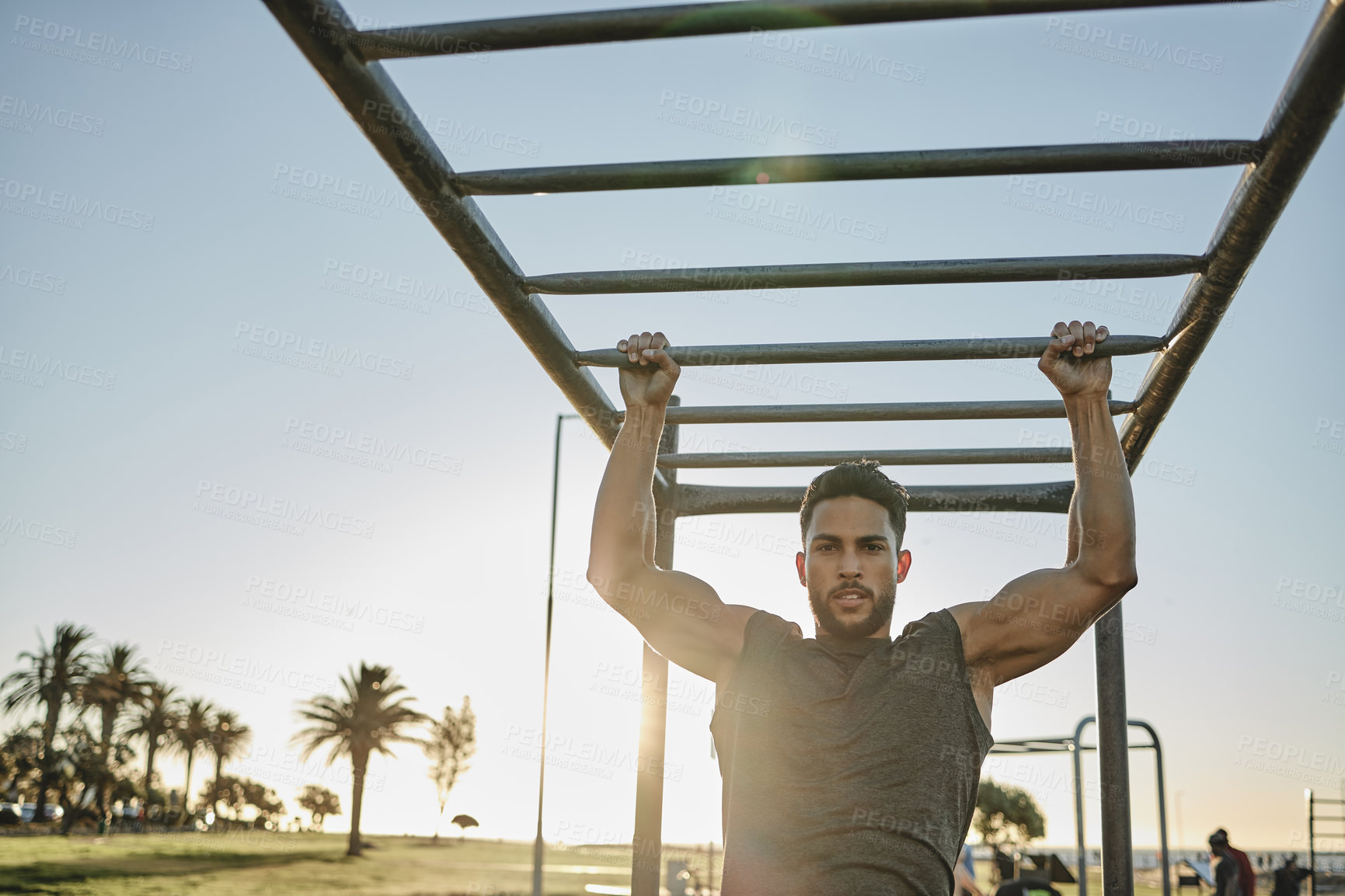 Buy stock photo Portrait of a muscular young man exercising at a calisthenics park