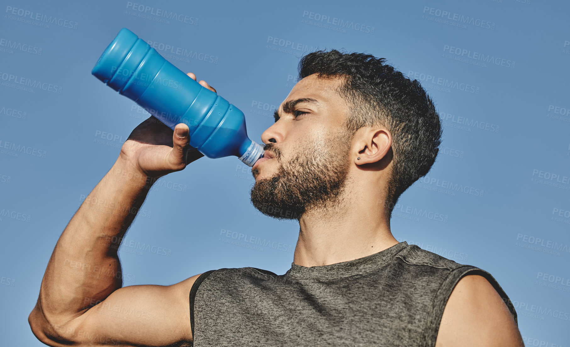 Buy stock photo Man, water bottle and drink with blue sky in nature, outside and hydration for exercise and thirsty. Fitness, healthy and cardio workout for male person, athlete and park for sports and run training