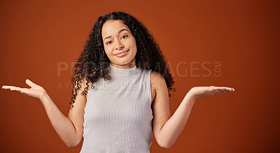 Buy stock photo Cropped portrait of an attractive young woman shrugging her shoulders in studio against a red background
