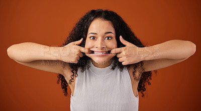 Buy stock photo Cropped portrait of an attractive young woman making a face in studio against a red background