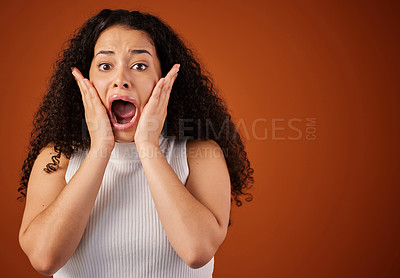 Buy stock photo Cropped portrait of an attractive young woman looking shocked in studio against a red background