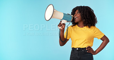 Buy stock photo Studio shot of an attractive young woman using a megaphone against a blue background