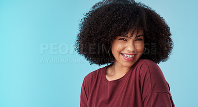 Buy stock photo Studio portrait of an attractive young woman posing against a blue background