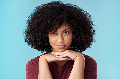 Buy stock photo Studio portrait of an attractive young woman posing against a blue background