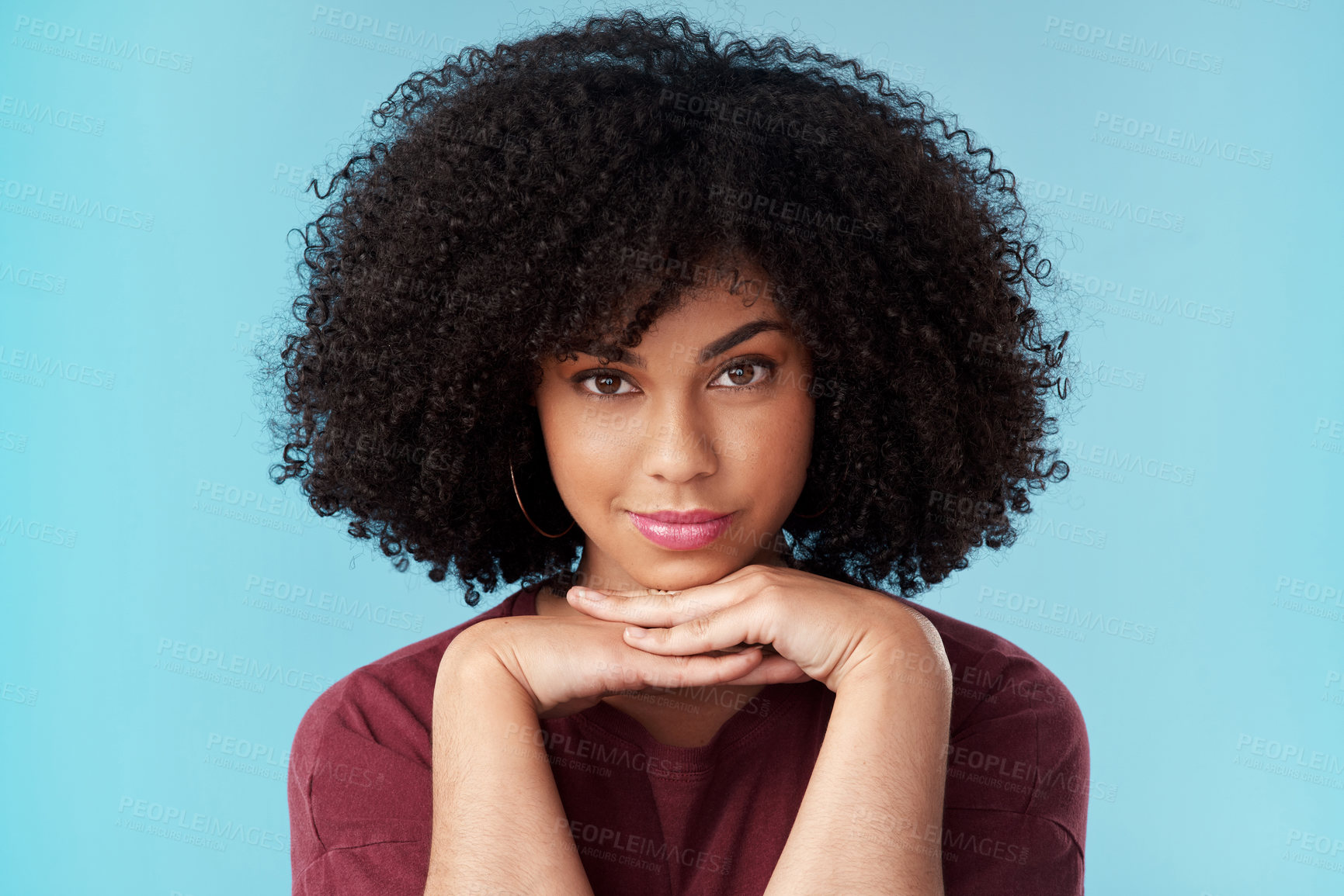 Buy stock photo Studio portrait of an attractive young woman posing against a blue background