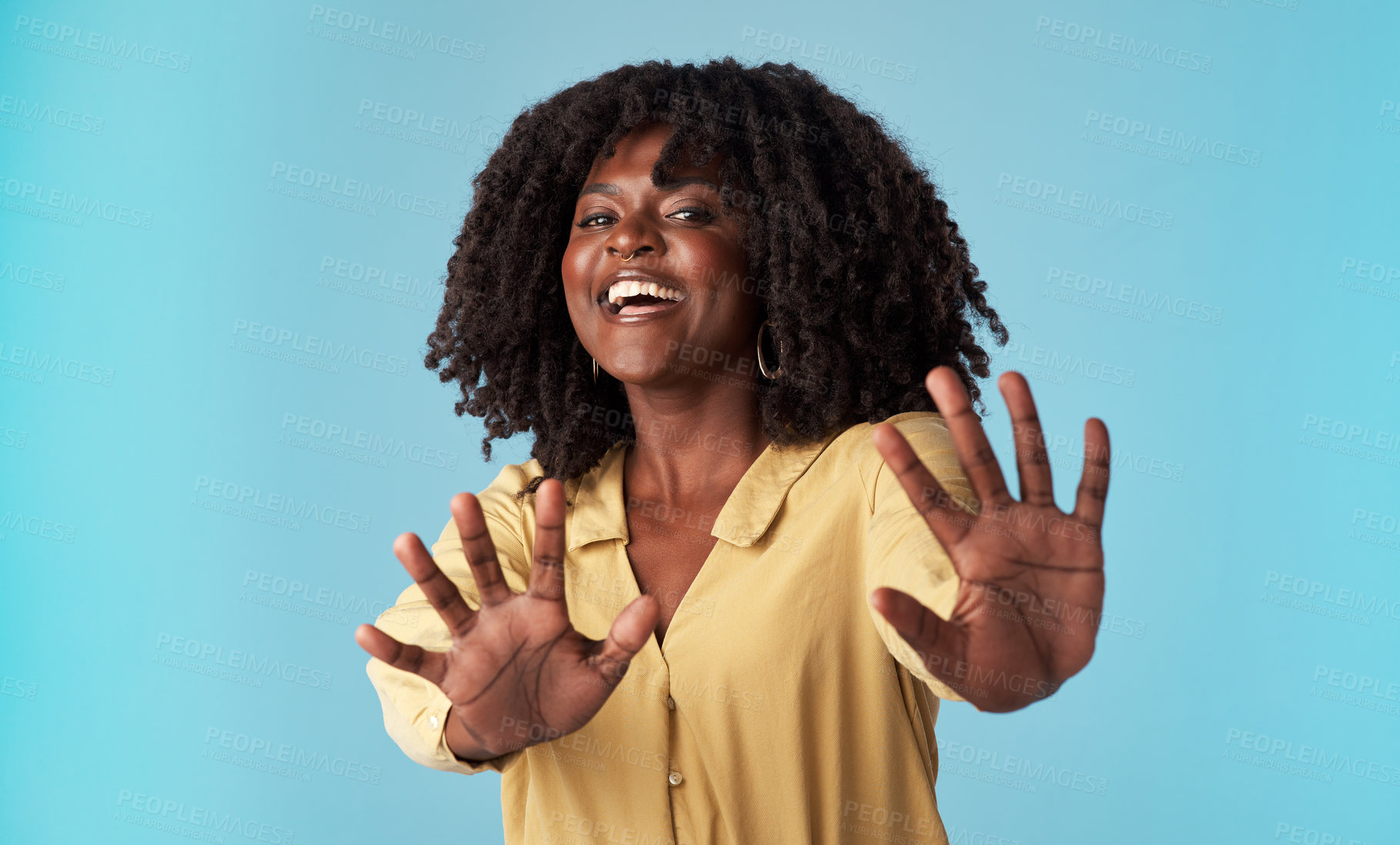 Buy stock photo Studio shot of an attractive young woman holding out her arms against a blue background