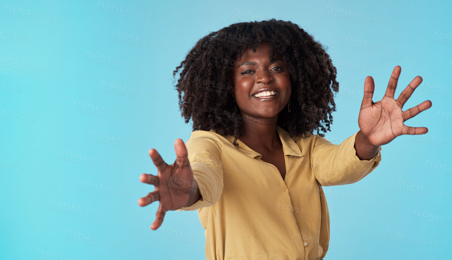 Buy stock photo Studio shot of an attractive young woman extending her arms against a blue background