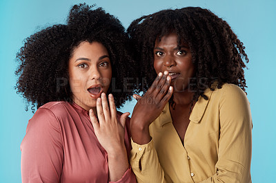 Buy stock photo Studio shot of two young women looking shocked against a blue background