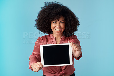 Buy stock photo Studio shot of a young woman holding a digital tablet with a blank screen against a blue background
