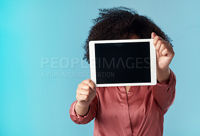 Buy stock photo Studio shot of a young woman holding a digital tablet with a blank screen against a blue background