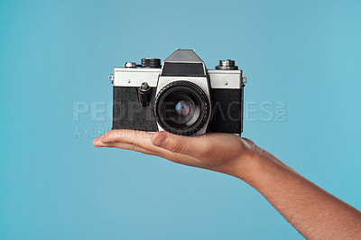Buy stock photo Studio shot of an unrecognisable woman holding a camera against a blue background