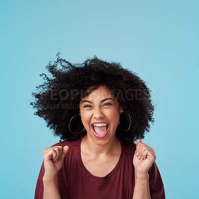 Buy stock photo Studio shot of an attractive young woman looking excited against a blue background