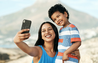 Buy stock photo Shot of a mother and her son taking selfies at the beach