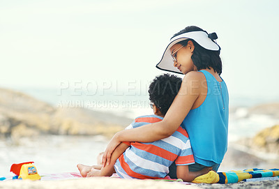 Buy stock photo Shot of s mother and son sitting on the beach looking at the view