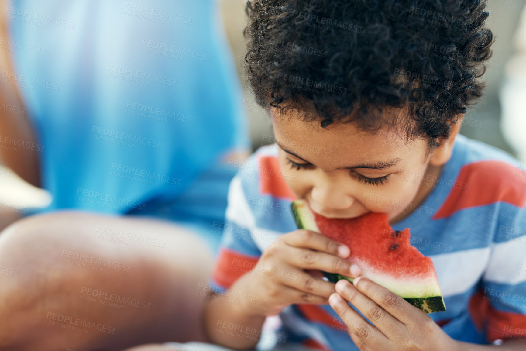 Buy stock photo Shot of a young boy enjoying a piece of watermelon outside