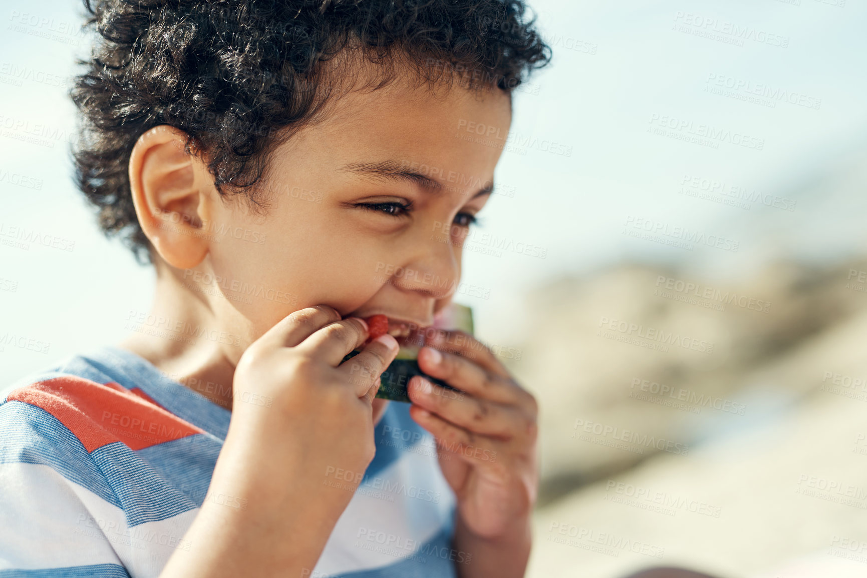 Buy stock photo Shot of a young boy enjoying a piece of watermelon outside