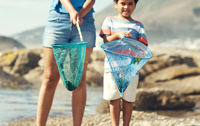 Buy stock photo Shot of a parent with their son at the beach holding fishing nets