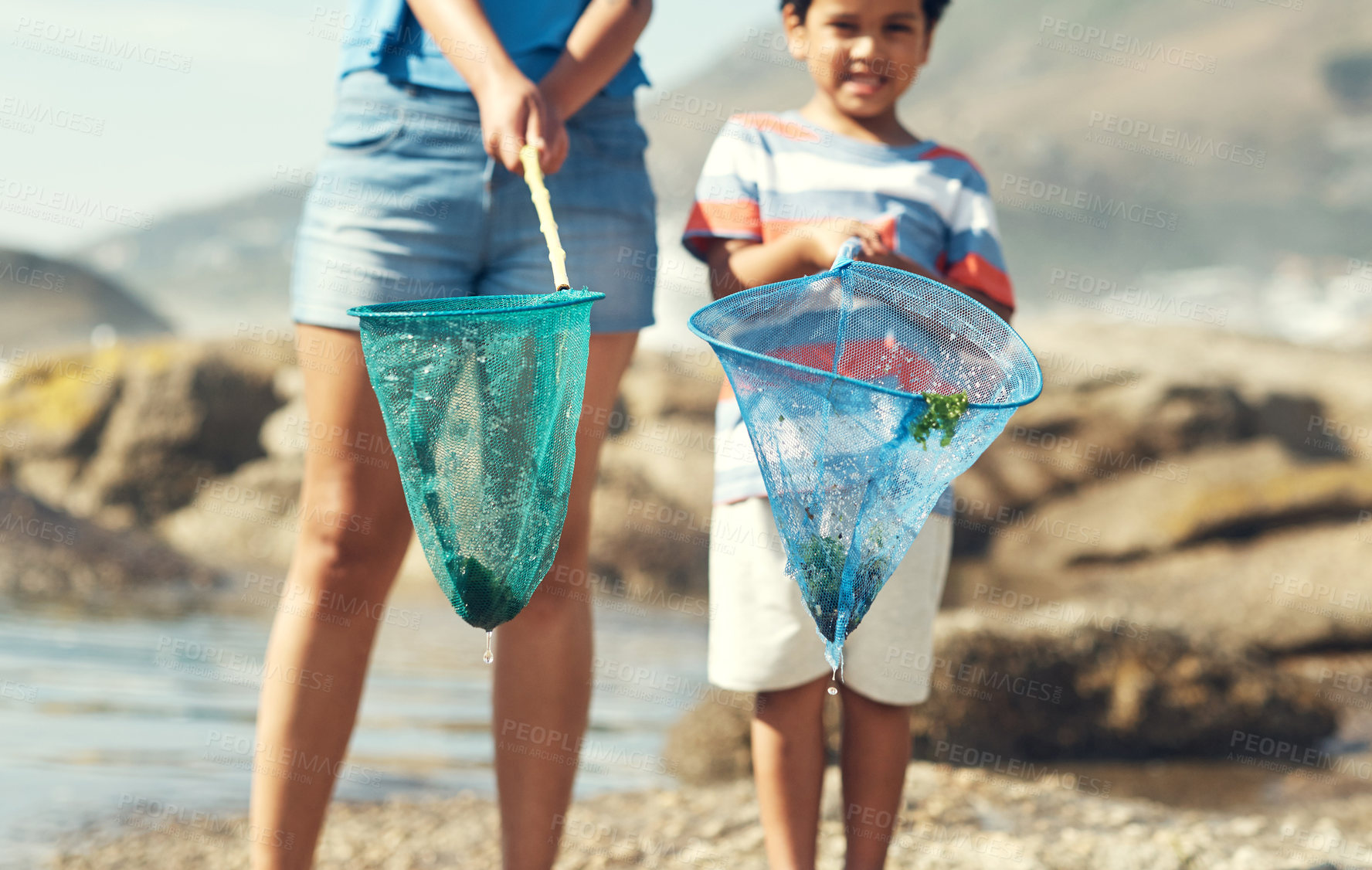 Buy stock photo Shot of a parent with their son at the beach holding fishing nets