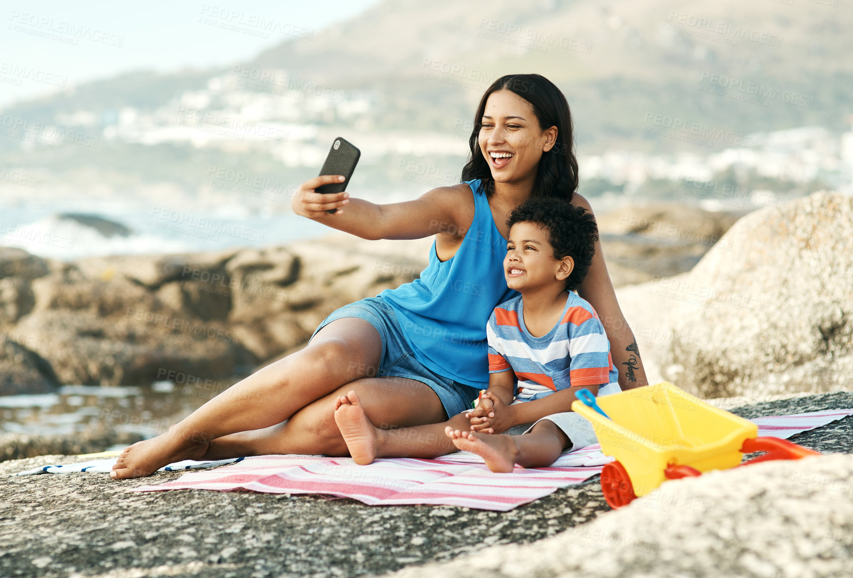 Buy stock photo Shot of a mother and her son taking selfies at the beach